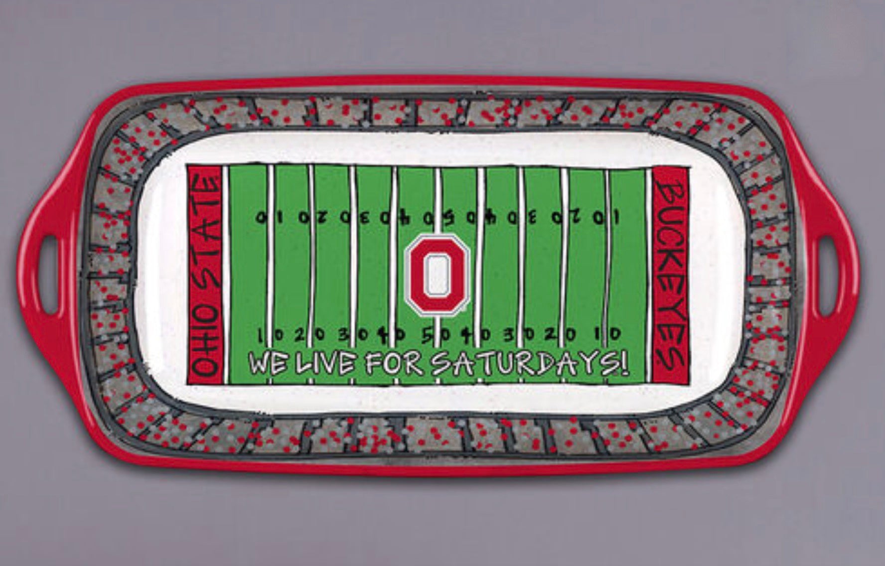 A rectangular serving tray with handles, decorated with an illustrated football field scene. The design shows a green field with yard lines, a large red Ohio State 'O' logo in the center, red side panels reading 'OHIO STATE' and 'BUCKEYS', and a gray stadium crowd border.