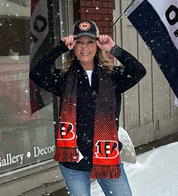 Person wearing a Bengals scarf and cap in the snow
