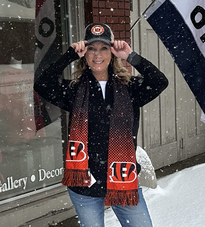 Person wearing a Bengals scarf and cap in the snow
