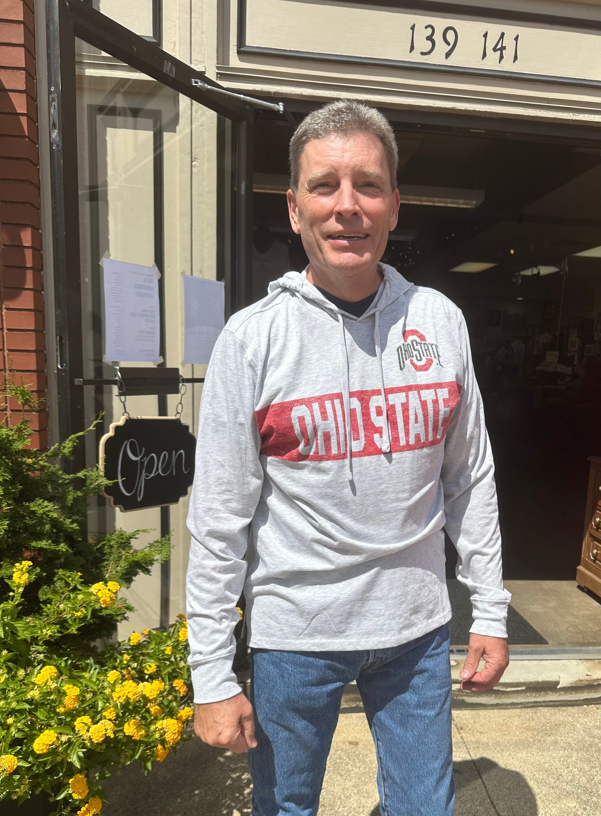 staffer wearing sweatshirt outside store