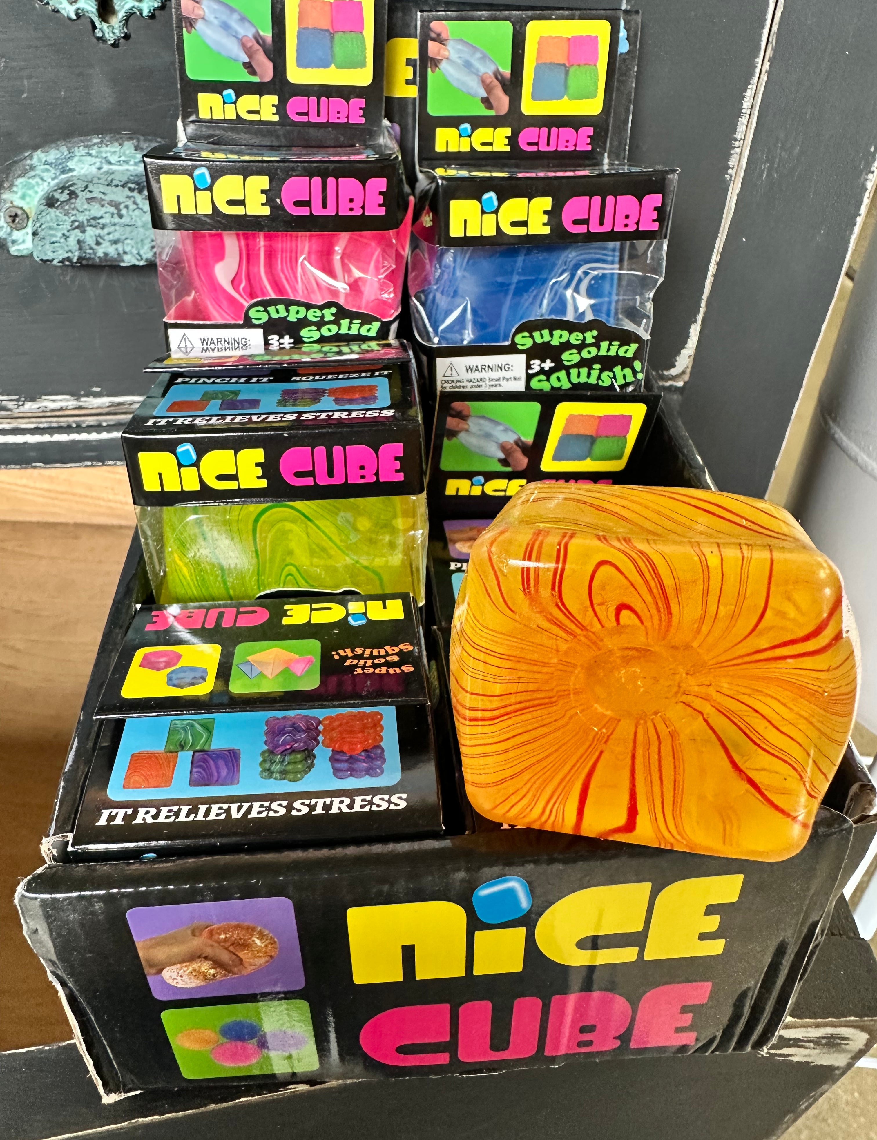 Display of 'Nice Cube' stress relief products with a colorful cube in front.
