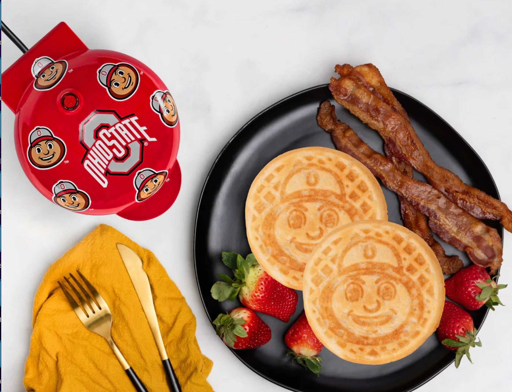 Brutus buckeye Two pancakes with face designs on a plate with bacon and strawberries, next to a red Ohio State-themed product.