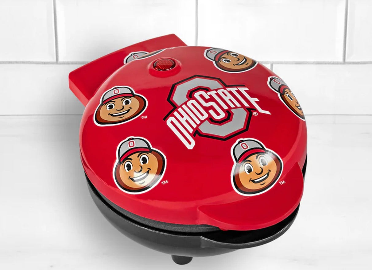 Red brutus buckeye Ohio State waffle maker with cartoon character faces on a white tiled background